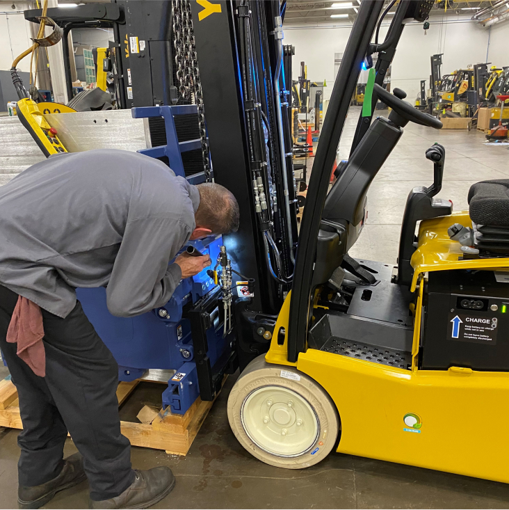 Repair technician looking at forklift